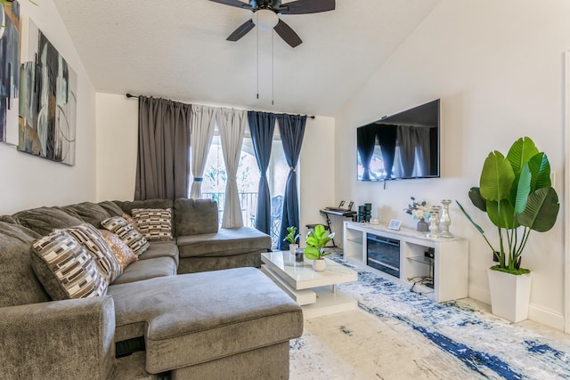 living room with a textured ceiling, ceiling fan, and lofted ceiling