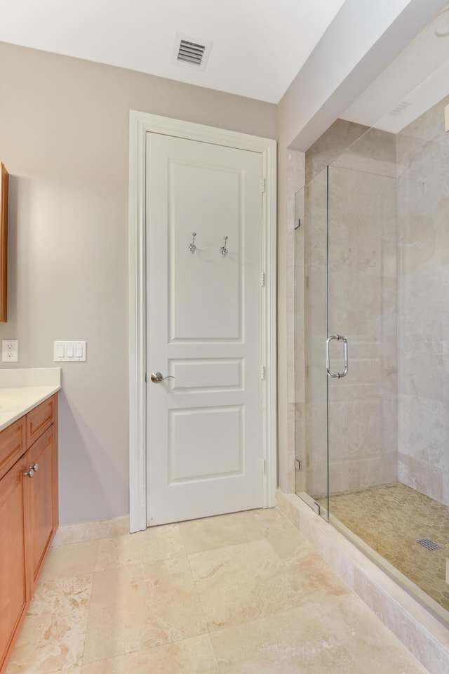 bathroom featuring vanity and a shower with door