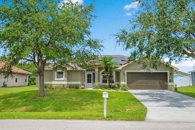 ranch-style home with solar panels, a garage, and a front yard