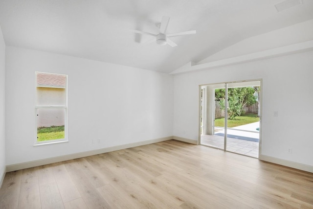 spare room with light wood-type flooring, vaulted ceiling, and ceiling fan