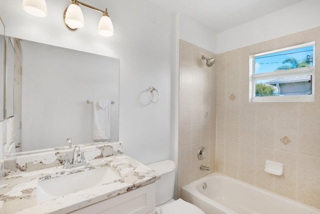 full bathroom with vanity, toilet, and tiled shower / bath