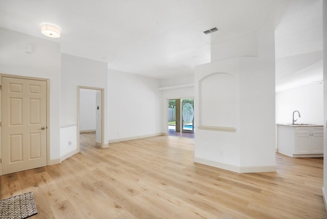 unfurnished room featuring sink and light hardwood / wood-style flooring