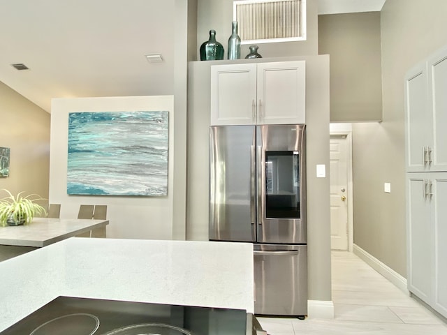 kitchen with white cabinetry and stainless steel fridge