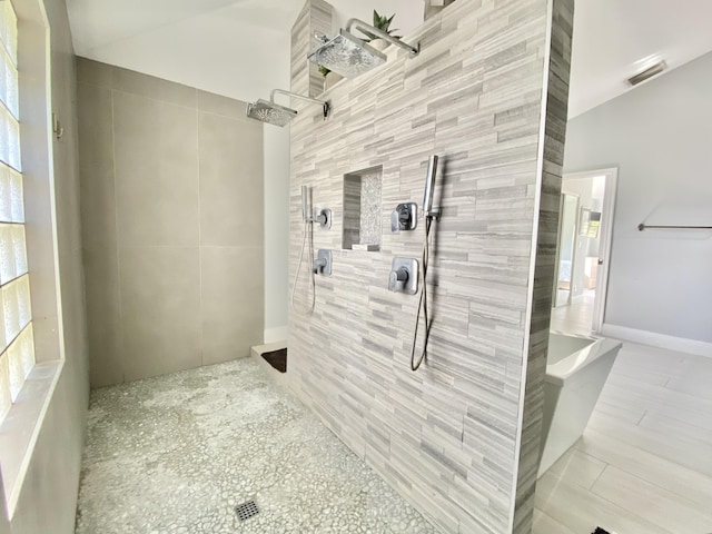 bathroom with a tile shower and tile walls