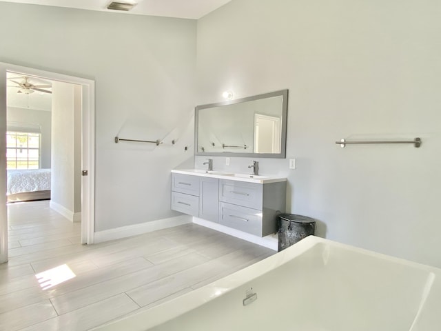 bathroom with a bathing tub, vanity, and wood-type flooring