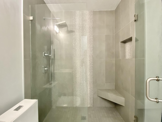 bathroom featuring tile patterned floors, toilet, and walk in shower