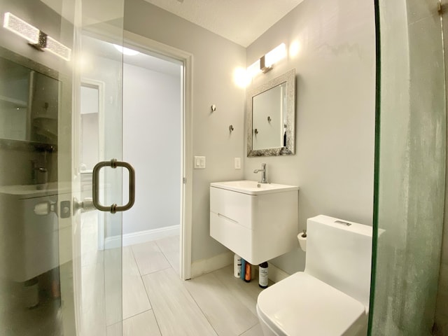 bathroom featuring tile patterned flooring, vanity, toilet, and walk in shower