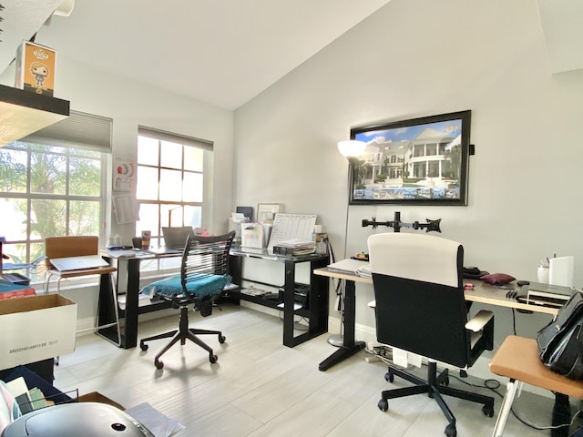 office space featuring light hardwood / wood-style floors and vaulted ceiling