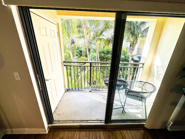 doorway to outside with dark wood-type flooring and a healthy amount of sunlight