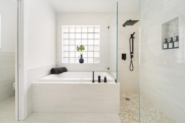 bathroom featuring tile patterned flooring, shower with separate bathtub, and toilet