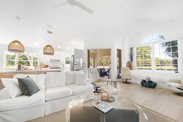 living room with ceiling fan, a healthy amount of sunlight, and lofted ceiling