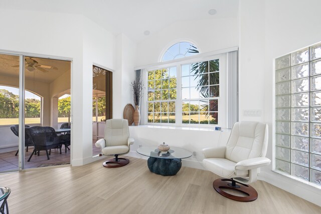 sitting room with ceiling fan, plenty of natural light, hardwood / wood-style floors, and vaulted ceiling