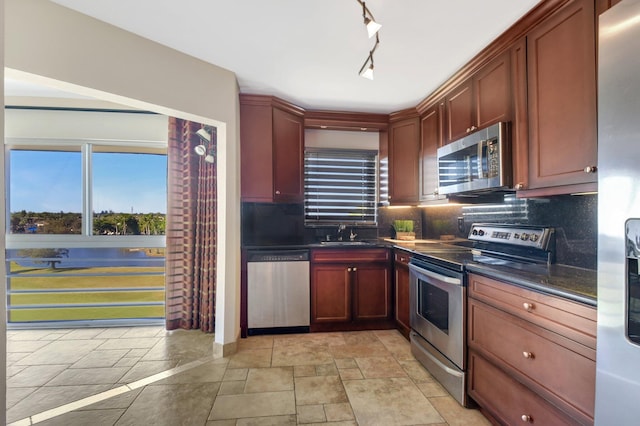 kitchen with backsplash, stainless steel appliances, a wealth of natural light, and sink