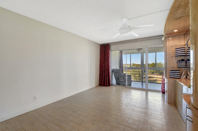 spare room featuring a textured ceiling, light wood-type flooring, and ceiling fan