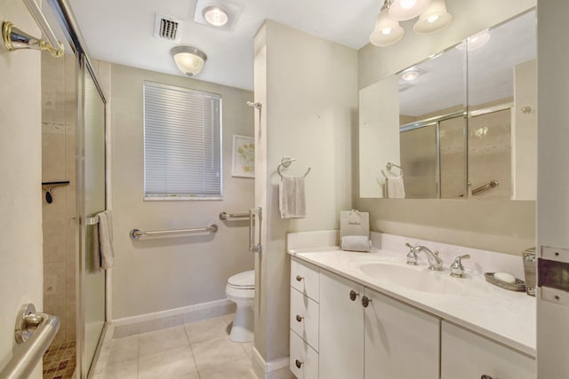 bathroom featuring toilet, vanity, tile patterned floors, and a shower with door