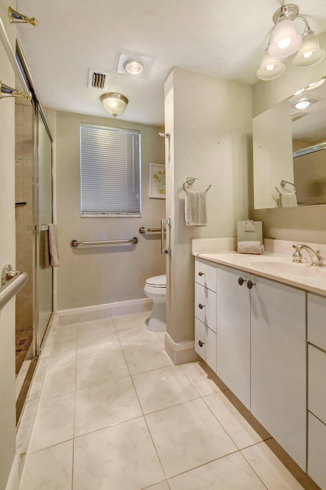 bathroom with tile patterned flooring, vanity, toilet, and a shower with shower door