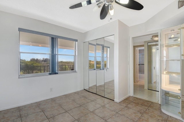 unfurnished bedroom with ceiling fan, a closet, and light tile patterned flooring