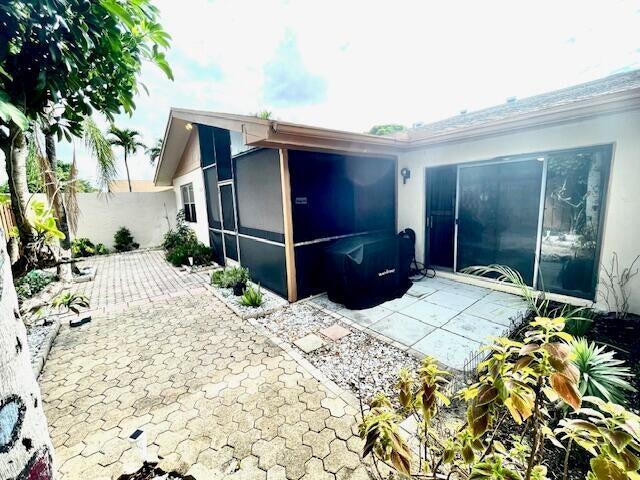 back of property featuring a sunroom and a patio area