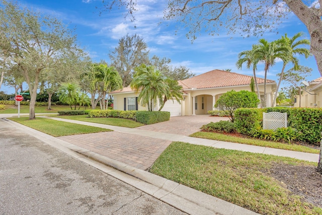 mediterranean / spanish-style home with a front yard and a garage