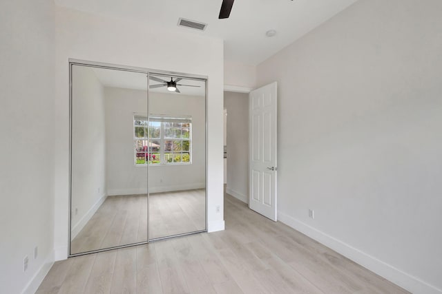 unfurnished bedroom with ceiling fan, light hardwood / wood-style floors, and a closet