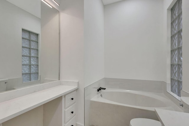 bathroom with vanity and a bath