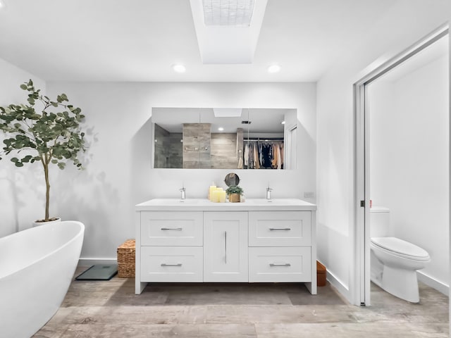 full bathroom with toilet, vanity, wood-type flooring, and shower with separate bathtub