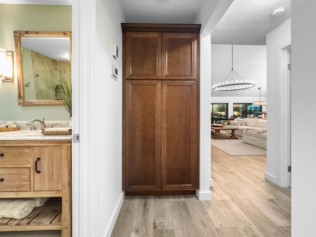 interior space with a chandelier, a textured ceiling, and light hardwood / wood-style flooring