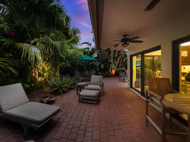 patio terrace at dusk featuring ceiling fan