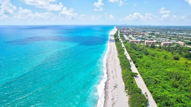 birds eye view of property with a water view and a beach view