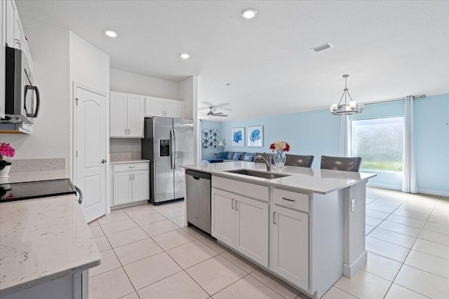 kitchen with sink, hanging light fixtures, an island with sink, white cabinetry, and stainless steel appliances