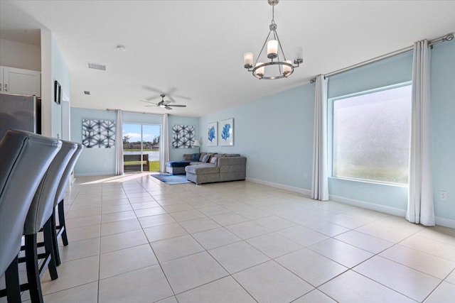 unfurnished living room featuring ceiling fan with notable chandelier and light tile patterned floors