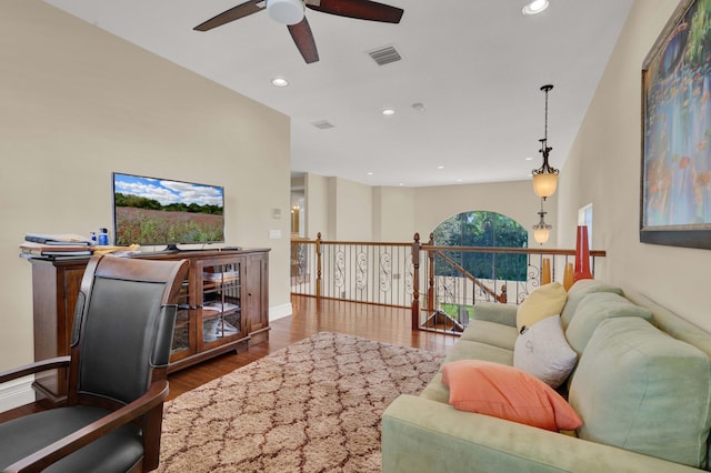 living room with ceiling fan and dark wood-type flooring