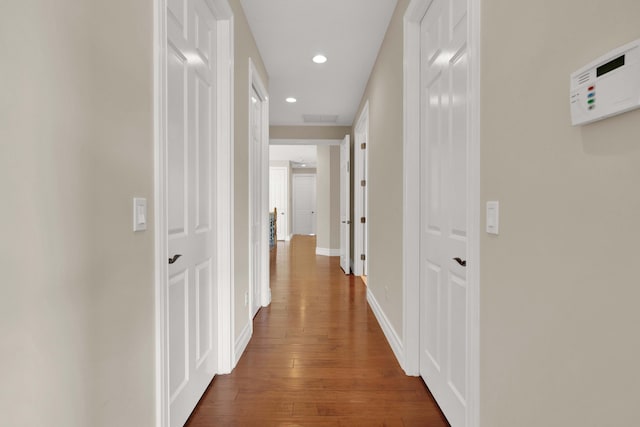 corridor with dark hardwood / wood-style flooring