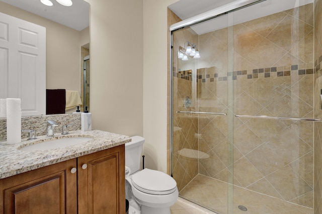 bathroom featuring tile patterned floors, vanity, toilet, and walk in shower