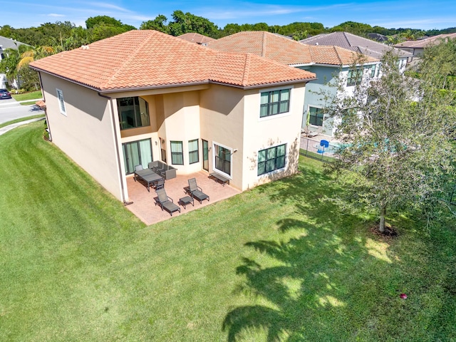 back of property with a patio area and a lawn