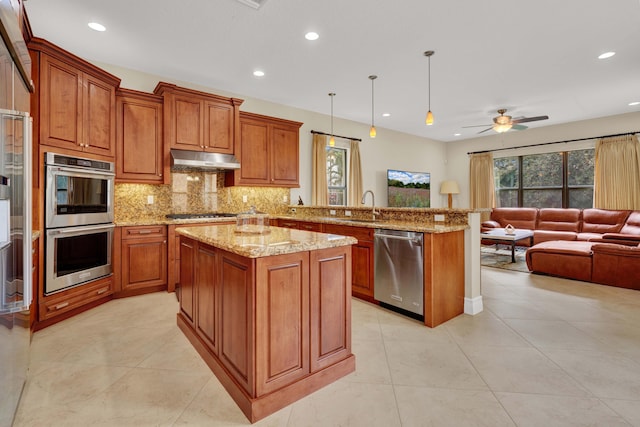 kitchen featuring pendant lighting, sink, ceiling fan, appliances with stainless steel finishes, and kitchen peninsula