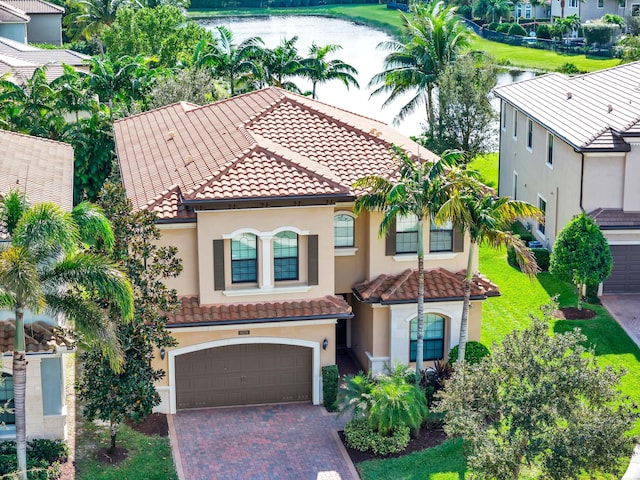 mediterranean / spanish-style home featuring a garage and a water view