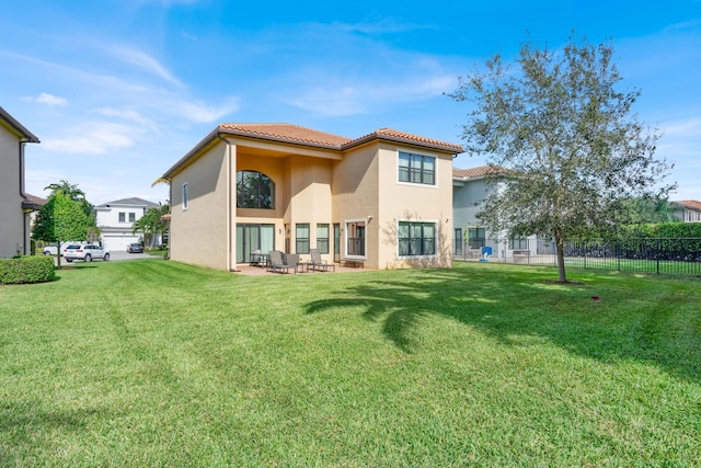 rear view of property featuring a lawn