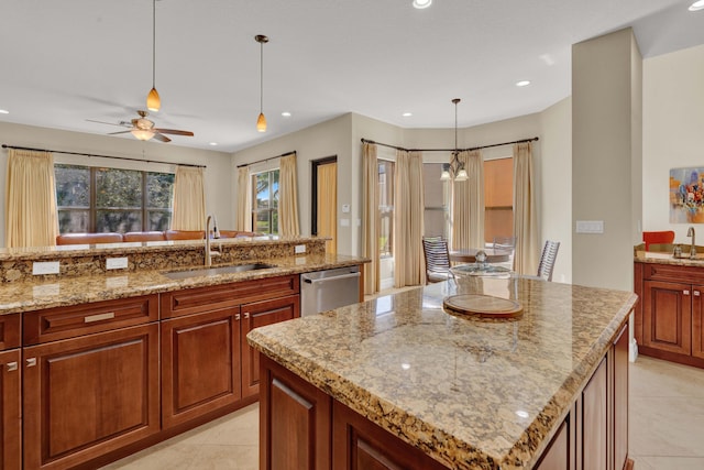 kitchen with light stone counters, stainless steel dishwasher, sink, light tile patterned floors, and a center island