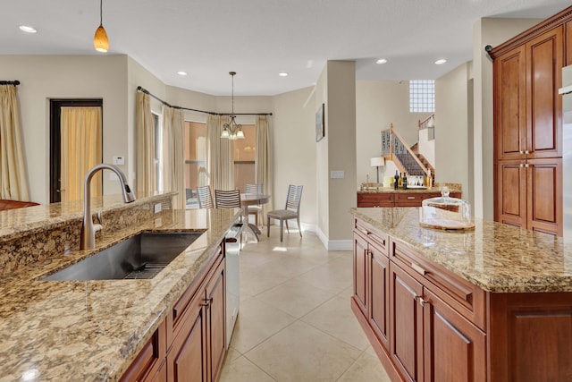 kitchen featuring a center island, sink, hanging light fixtures, light stone countertops, and a notable chandelier