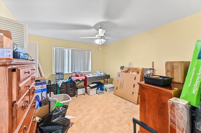 office space with light carpet, ceiling fan, and a textured ceiling