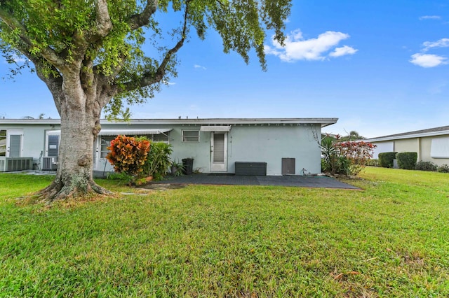 rear view of house with a lawn, a patio, and central AC unit