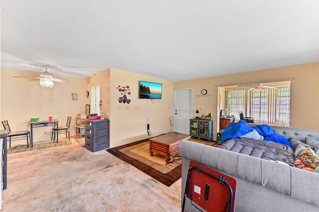 carpeted living room with ceiling fan and a textured ceiling