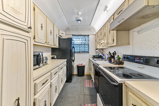 kitchen featuring a raised ceiling, sink, and black appliances