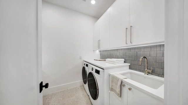 washroom with cabinets, independent washer and dryer, and sink