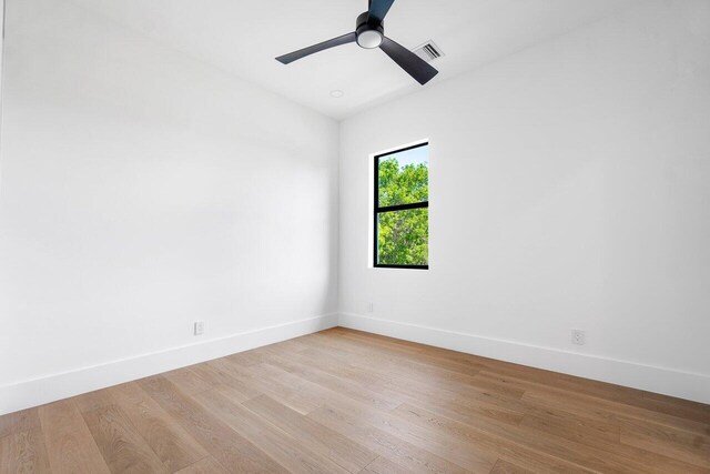 bathroom with wood-type flooring, a tile shower, and ceiling fan