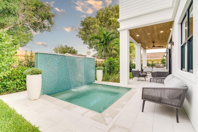 view of swimming pool with an outdoor living space, ceiling fan, a patio, and pool water feature