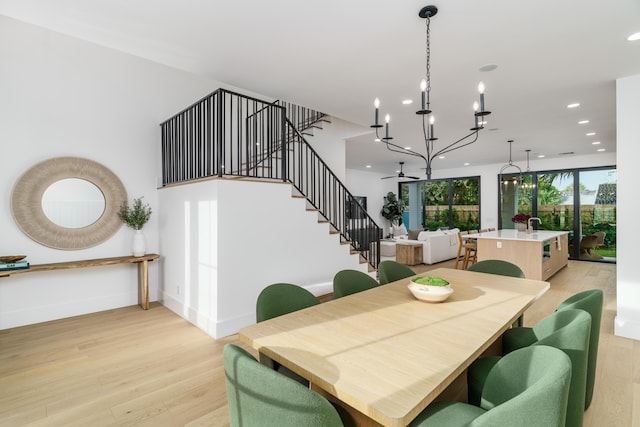 dining space featuring a notable chandelier and light wood-type flooring