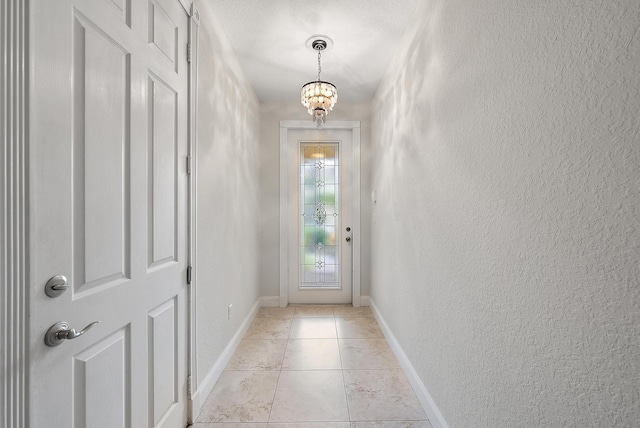 doorway to outside featuring an inviting chandelier and light tile patterned flooring