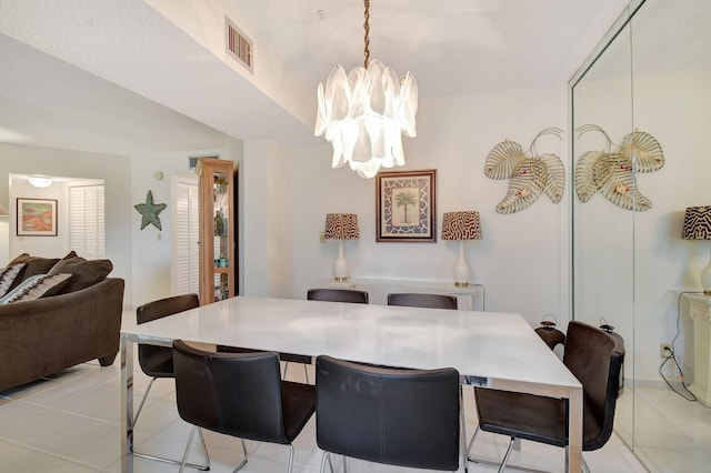 tiled dining room featuring a chandelier